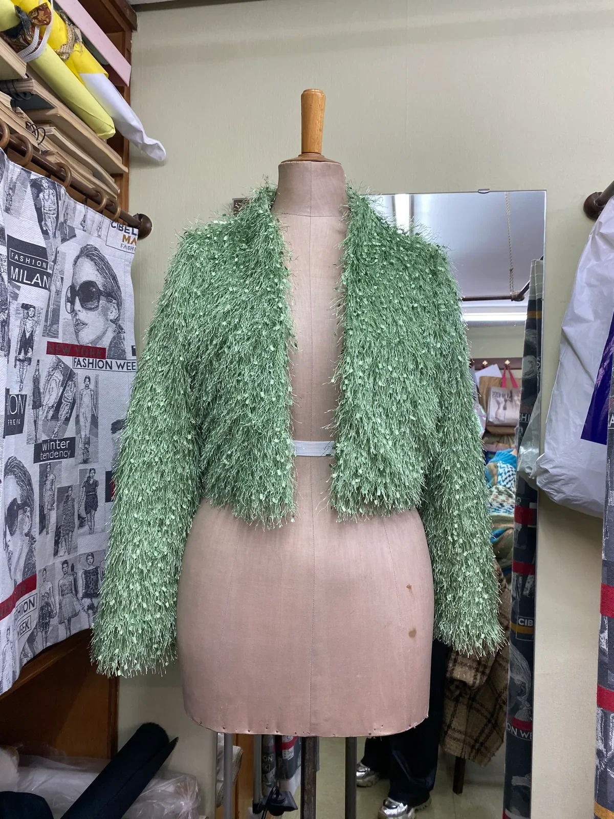 Vista frontal de la Chaqueta Césped verde de textura con flecos sobre maniquí