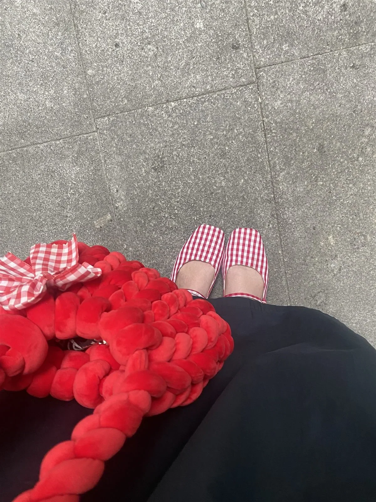 Vista desde arriba de un look con cuadros vichy rojos y blancos, azul marino y un accesorio rojo
